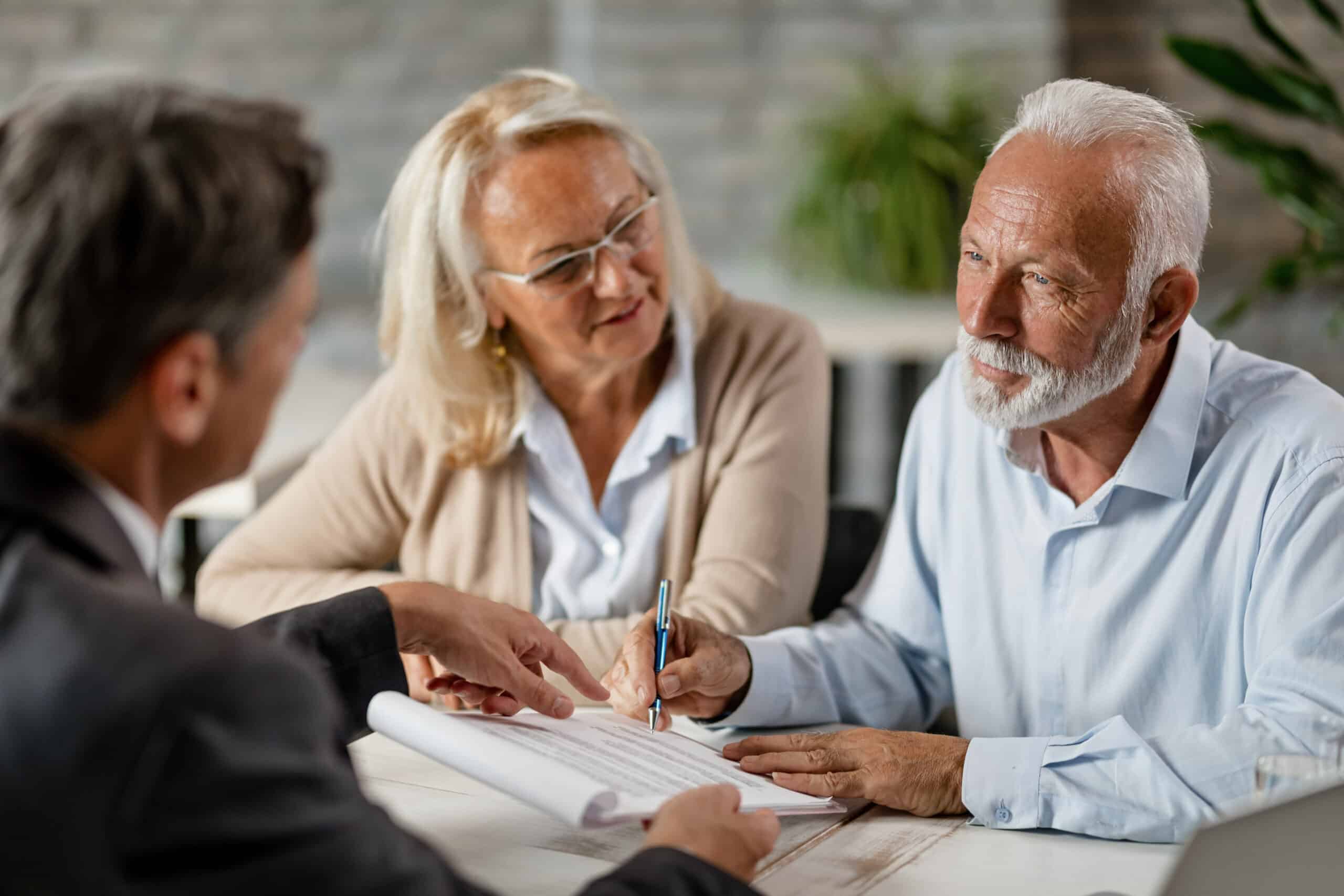 Senior Couple Signing A Contract While Having A Meeting With Ins Mature Couple Having Meeting With Bank Manager Signing Lease Agreement Office Focus Is Mature Man Scaled - Springbrook Assisted Living